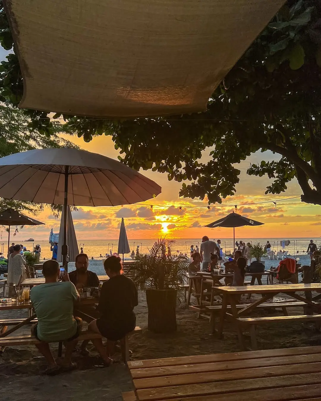 Atardecer sobre el mar desde las mesas en la arena de Cambiante al Mar, en Pozos Colorados
