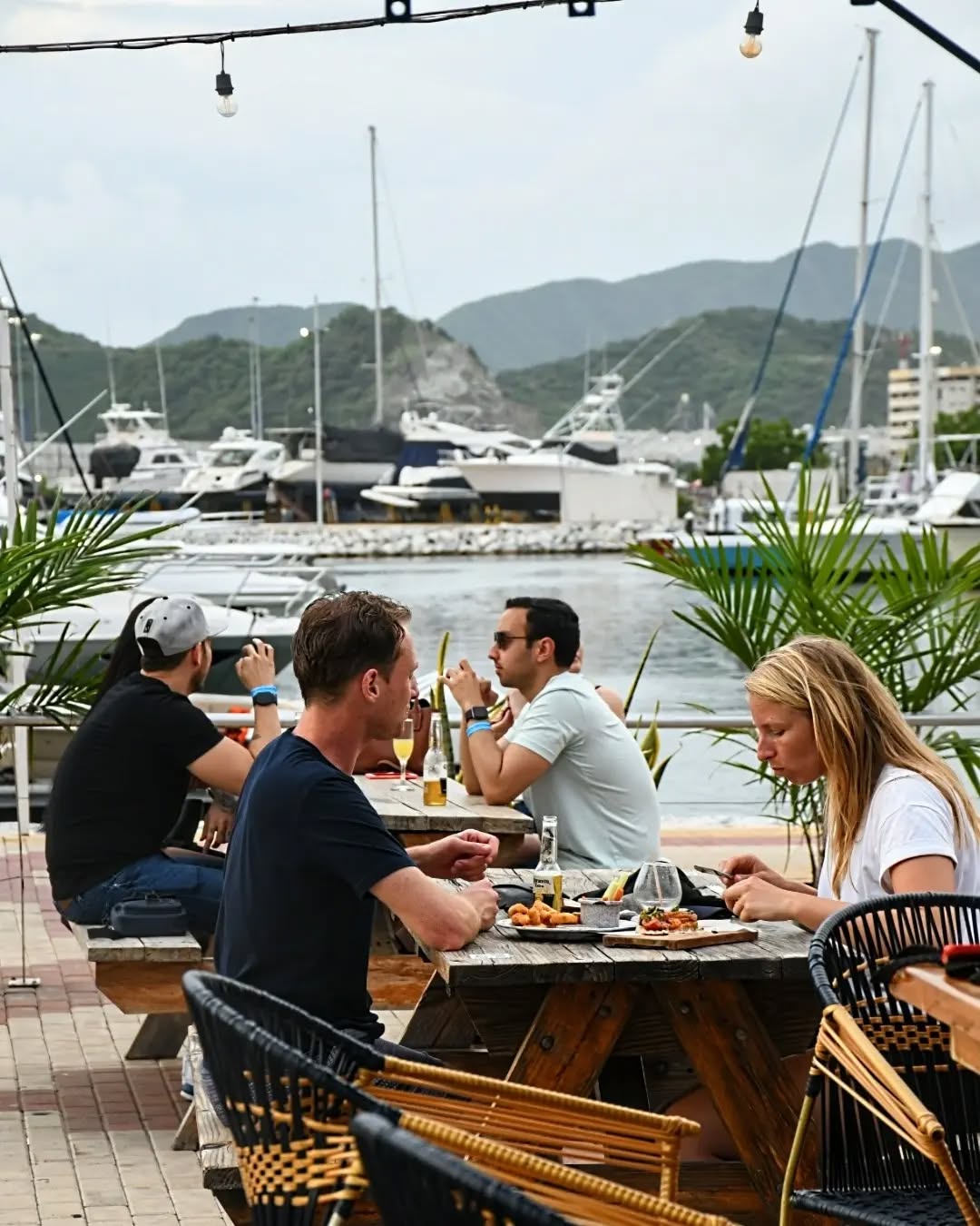 Comensales en Cambiante Marina con los veleros de la Marina Internacional al fondo
